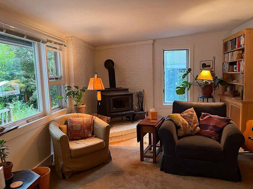 Living room with wide screen TV, wood burning stove with glass door for watching the flames. games and puzzles, library of great books and day bed.