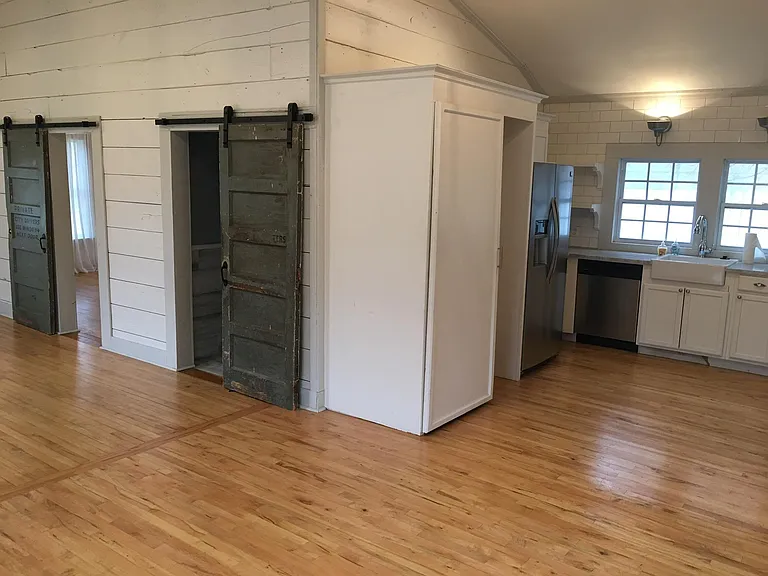 Kitchen, doors to bathroom and master bedroom. Cabinet is for washer dryer