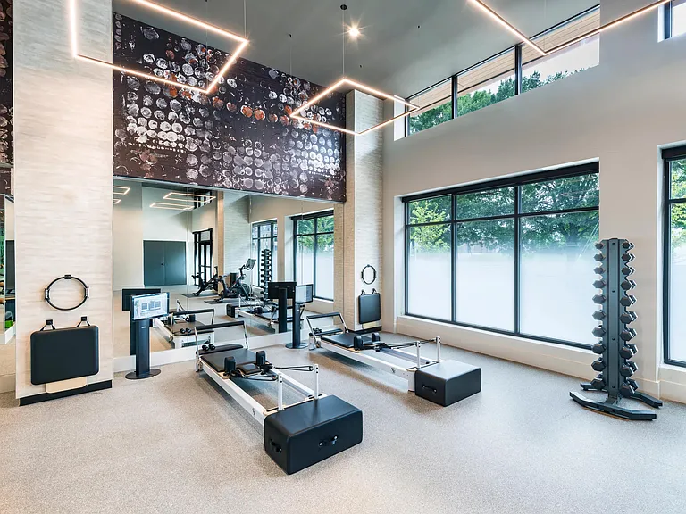 Light-filled fitness studio with reformer machines and strength equipment designed to support every workout.