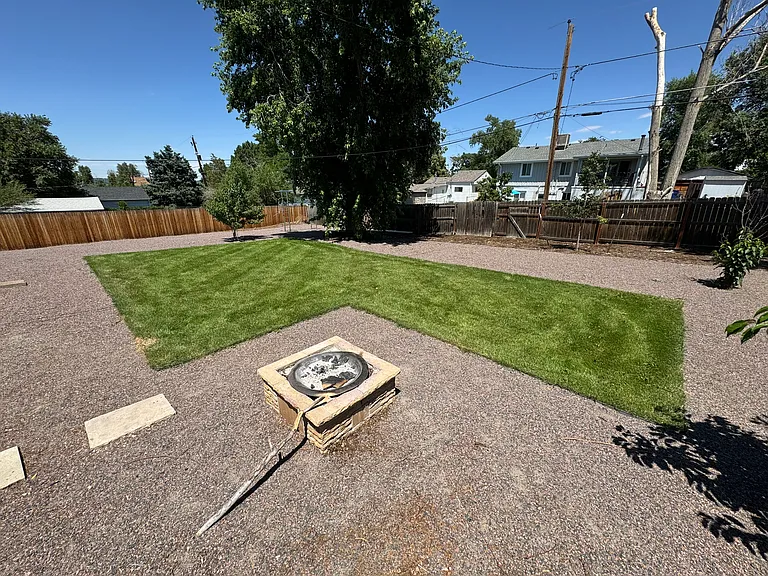 Large back yard and fire pit, with integrated sprinkler system.