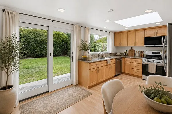 Kitchen with large skylight, leads out into backyard. All stainless steel appliances.