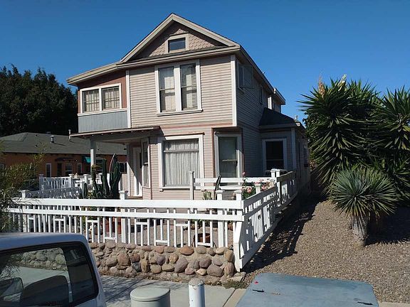 Front view of residence, and fenced in front yard.