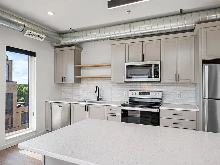 Modern kitchen with sleek stainless steel appliances, stylish gray cabinetry, and bright natural light. Modern kitchen with sleek stainless steel appliances, stylish gray cabinetry, and bright natural light.