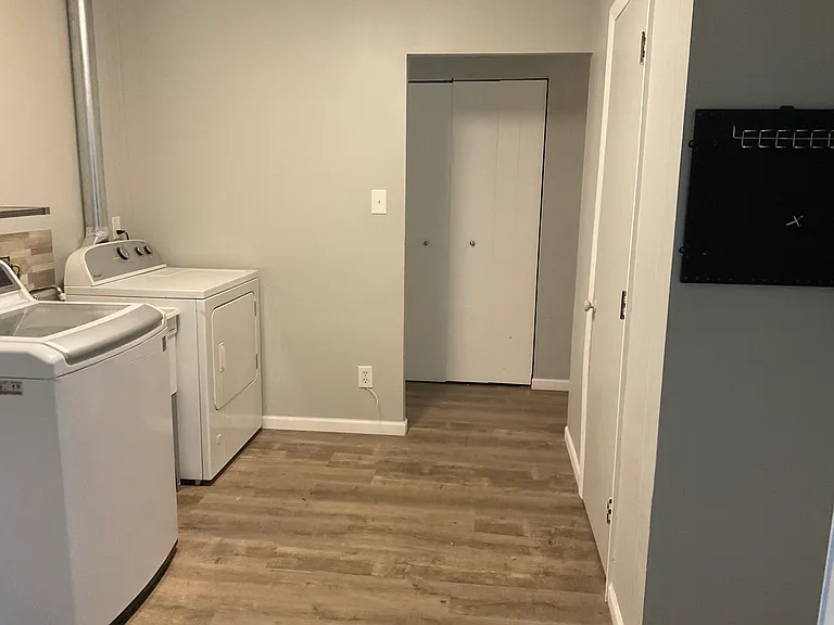 Laundry room with view of furnace closet and hallway storage closet