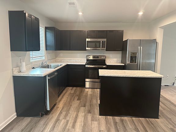 Kitchen. Includes microwave, stove, oven, dishwasher, and fridge.