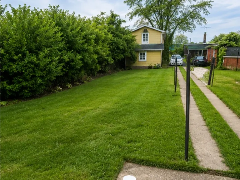 View of back yard, two story detached garage/workshop and off street parking