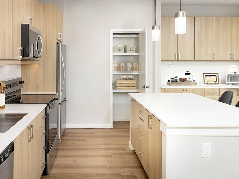 Finish Package II kitchen with stainless steel appliances, oak cabinetry, white tile backsplash, white quartz countertop, and hard surface flooring