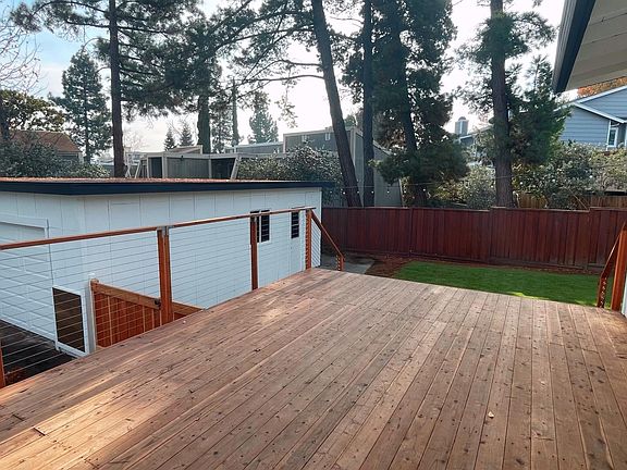 Brand new redwood deck with cable railing and beautiful trees in the background