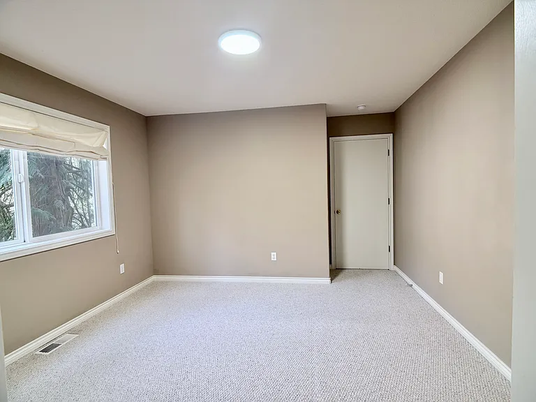 Well-proportioned bedroom with a serene, low-light ambiance in the early morning hours.