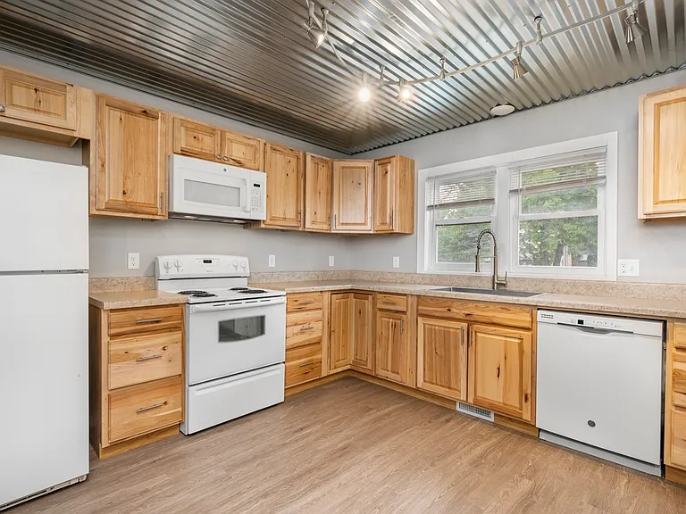 Modern kitchen with rustic wooden cabinets, sleek appliances, and a bright window offering natural light. Modern kitchen with rustic wooden cabinets, sleek appliances, and a bright window offering natural light.