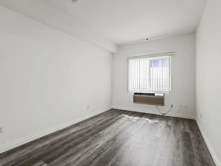 Bedroom with Vinyl Flooring, AC Unit, and Large Window