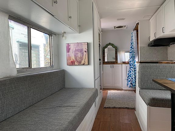 This is a sleeper couch, and the queen size bed is behind this image. The camper has one tall closet w room for 50+ hangers. along both walls as the image shows there is allot of over head closet space for folded items.