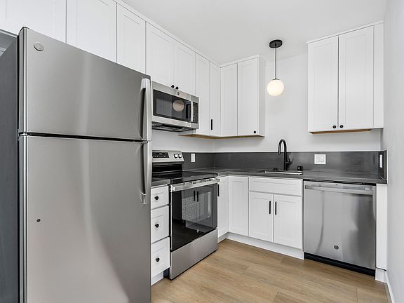 Brand new kitchen with refrigerator, oven, microwave, dishwasher.