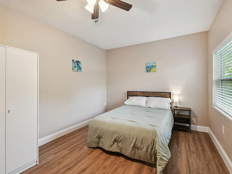 Full size cozy bed, with end table, light, desk, office chair, storage container under the bed and large Armoire