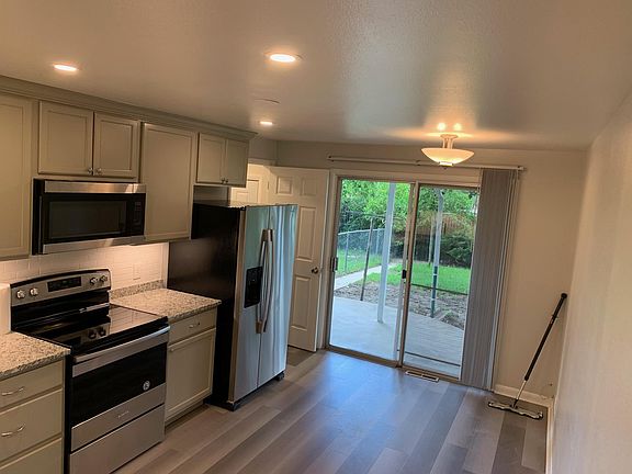 Modern Updated Kitchen with a covered patio off the back for entertaining. The backyard includes a large paver area.