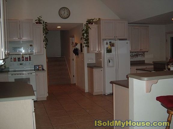 Whitewashed custom wood cabinets and solid surface work area/sink.