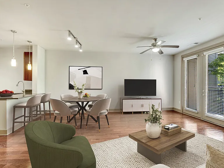 A living room with a green armchair, a wooden coffee table, and a television.