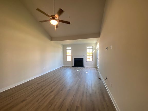 Living Area with fan, LVP floor, gas fireplace, and vaulted ceiling