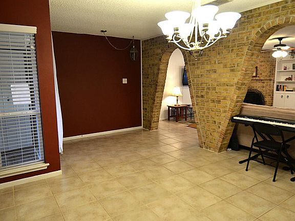 Entering the home, is a nicely arched exposed brick wall into the family room.