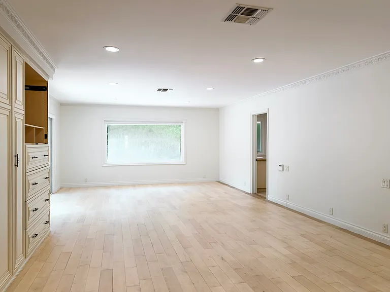 Unfurnished bedroom with a high window and en-suite bathroom access adds privacy to this Beverly Hills luxury rental at 1094 Garden Lane, a 90210 lease.