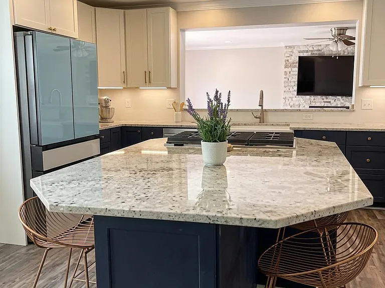 Gourmet kitchen with a large stone island, bar seating, and ample cabinetry, opening to the living area for easy hosting.