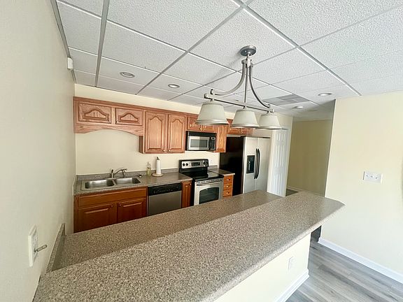 Kitchen with stainless steel appliances and bar height counter for additional eating space