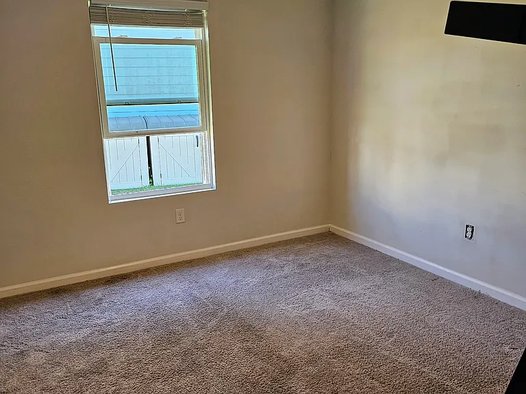 Bedroom 2 off the laundry hallway. This bedroom is larger than bedrooms 3 and 4 and has a fan and large closet.
