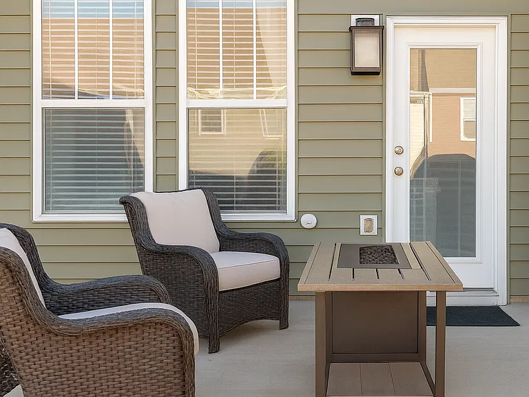 Private fenced backyard with patio seating, perfect for outdoor dining, grilling, and relaxing. (Furniture not included in the rental)