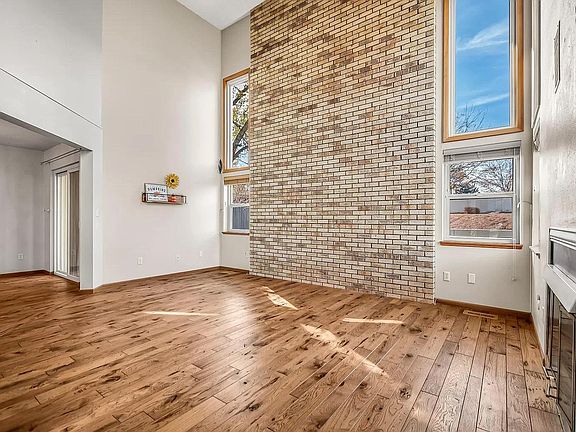 Large living room with passive solar trombe wall for winter heat absorption.