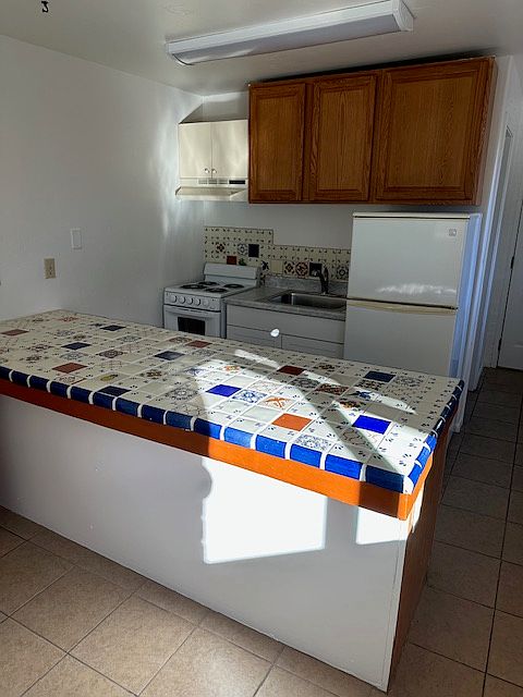 Beautiful talavera tile counter separates kitchen from living/bedroom area