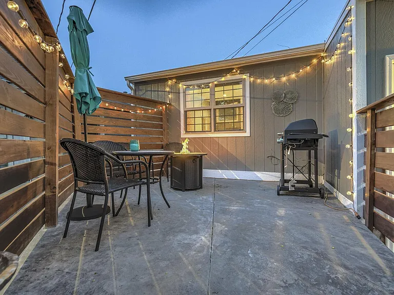 Cute front yard with a fire pit, grill, table and chairs!