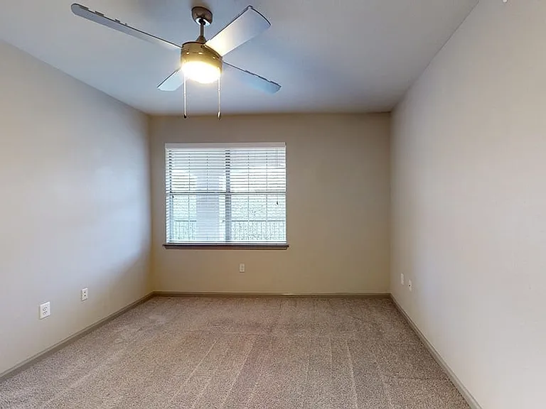 Spacious apartment bedroom with plush carpet flooring