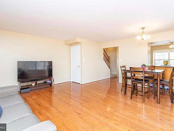 Main level living space. White door is door to basement. Please note- this picture prior to our ownership now with updated light fixture (very similar) and wooden cabinet doors painted white.
