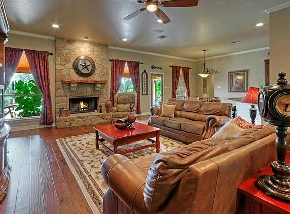High ceilings and a fireplace featuring floor to ceiling rock work and a custom made, hill county me