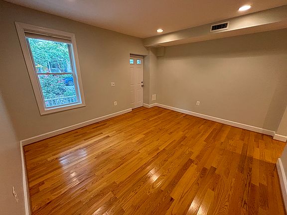 Living room (first room you walk into the house), with hardwood floors and recessed lighting.