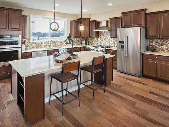 Kitchen area showcasing large center island with additional seating and stainless steel appliances