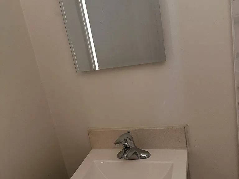 Bathroom vanity area features a single-basin sink with chrome faucet and a wall-mounted mirrored medicine cabinet.