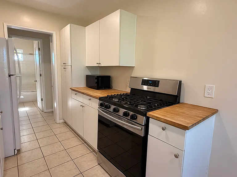 Kitchen. Newer gas range, fridge, butcher block and tile counters.