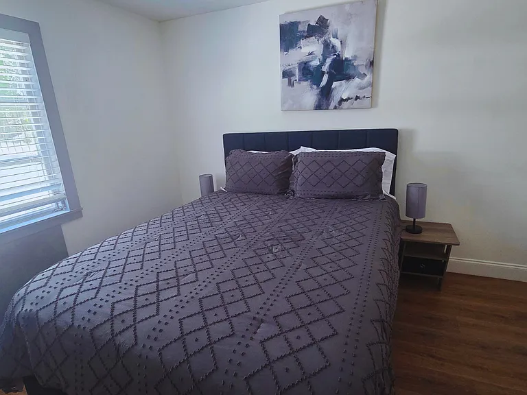 Relax in a bright, cozy bedroom with premium linens and a plush queen bed.