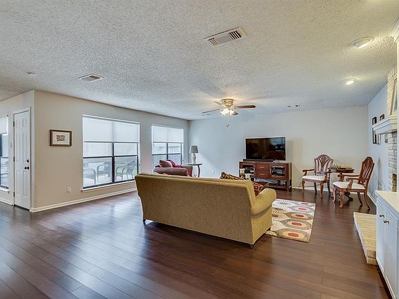 Spacious living room with lots of natural light, ceiling fan and built-in bookcase.