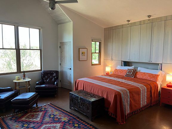 Luxe main bedroom with Cal King bed, soaring ceilings, custom cabinetry, wood-burning fireplace, HD Smart TV