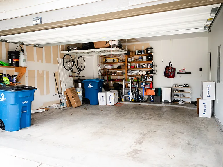 Spacious 2-car garage with built-in storage shelves and ceiling storage unit!