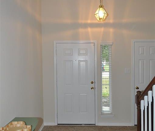The inviting foyer features 20 ft. ceiling and tile flooring.