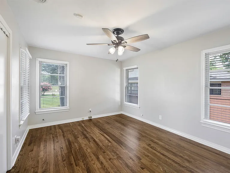 Master bedroom with hardwood / wood-style flooring and ceiling fan