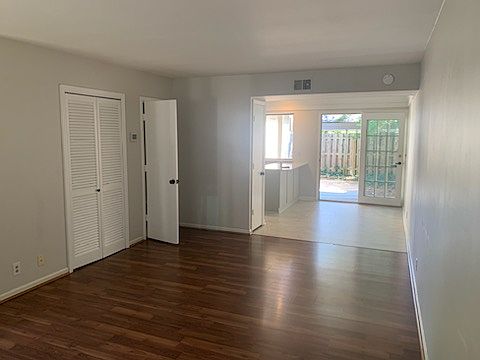 living room with view into dining/kitchen area. Washer dryer hook ups on door to the left, and half bath is door on the right.