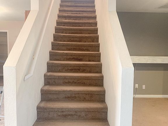 Stairway located between living room and kitchen