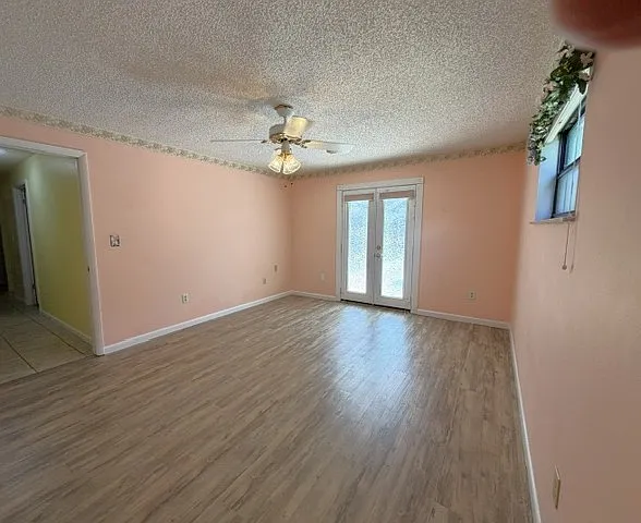 Master bedroom. French doors lead out to pool enclosure. The French doors have a window film that lets in light which usually reaches this room in the afternoon or evening. There are fabric blinds on the door for a bit more privacy.
