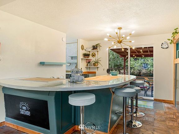 Mid-century designed eat-in kitchen that offers large counter space and an ample range of seating. 
