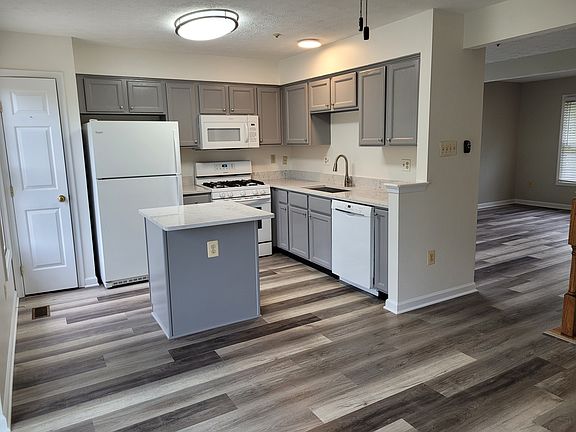 Elegantly renovated kitchen with quartz countertops and luxury vinyl plank floors.