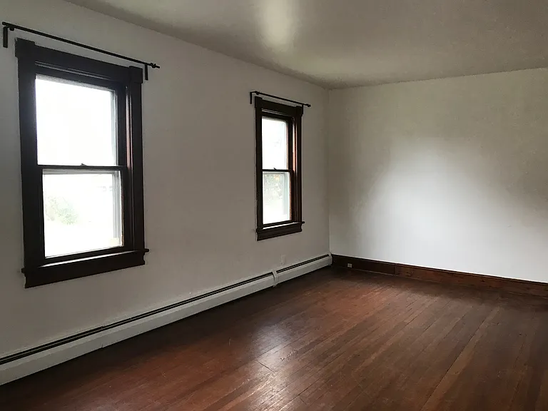 Large sunny living room/dining room with hardwood floors and brand new windows
